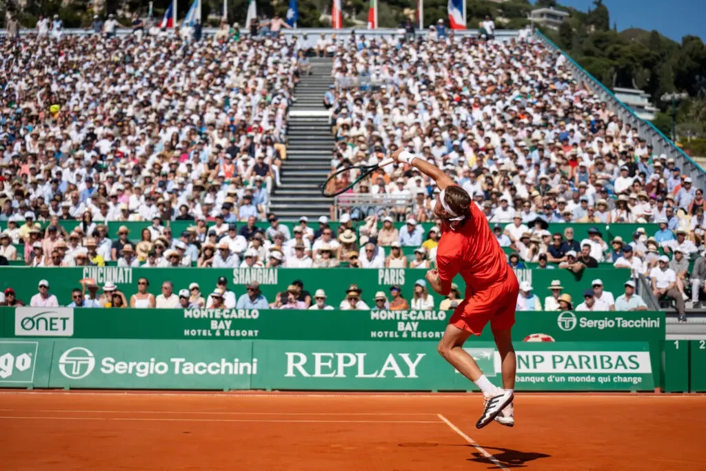 A professional tennis player about to start a tennis match in front of a audience on a tennis court