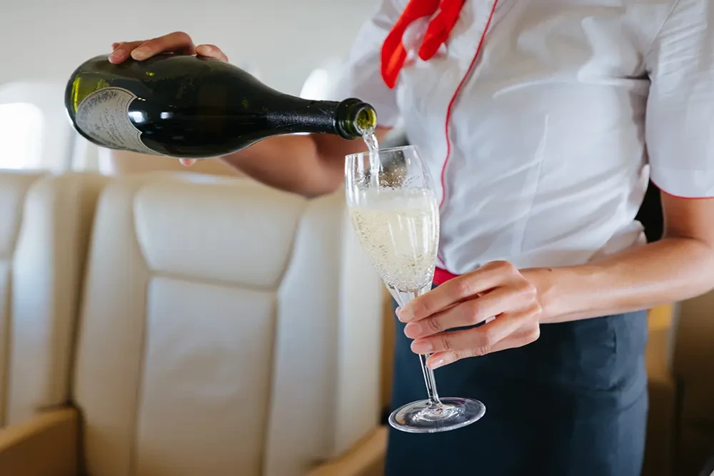 VistaJet Hostess Pouring Champagne
